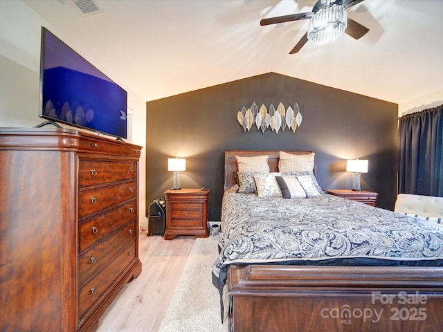 bedroom with lofted ceiling, visible vents, ceiling fan, and wood finished floors