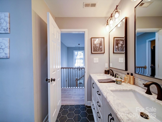 bathroom featuring double vanity, a sink, and visible vents