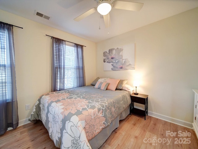 bedroom featuring wood finished floors, visible vents, and baseboards