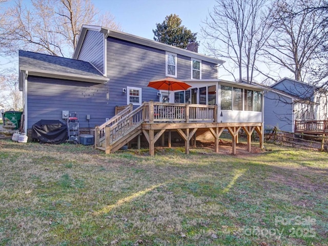 back of property featuring a yard, a chimney, stairway, a sunroom, and a deck