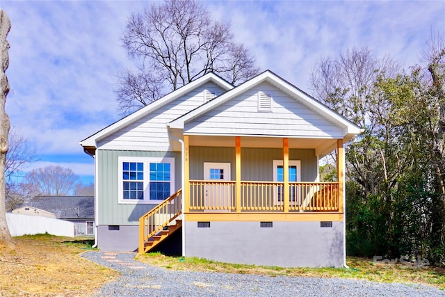 view of front of home featuring a porch, crawl space, and stairs