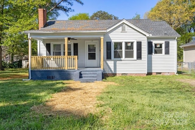bungalow-style home featuring a front lawn, covered porch, crawl space, and a chimney