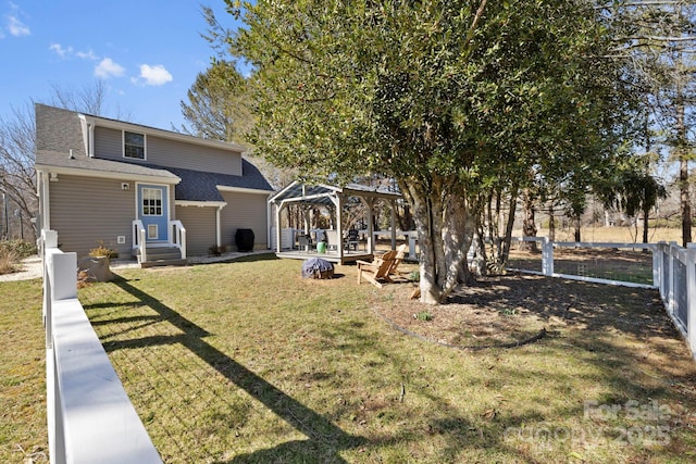 exterior space featuring a gazebo, a yard, fence private yard, and a shingled roof