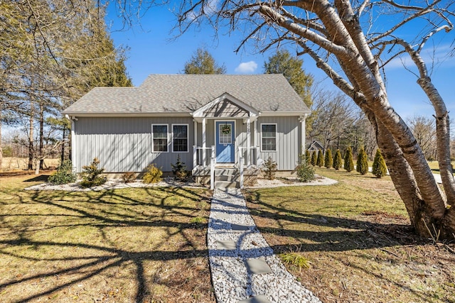 view of front of home featuring a front yard and roof with shingles