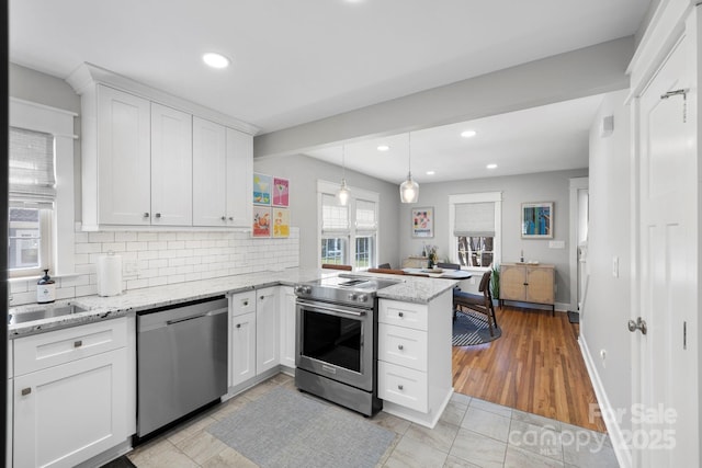 kitchen featuring a peninsula, recessed lighting, appliances with stainless steel finishes, white cabinetry, and backsplash