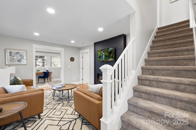 living area with stairway, recessed lighting, baseboards, and light wood-type flooring