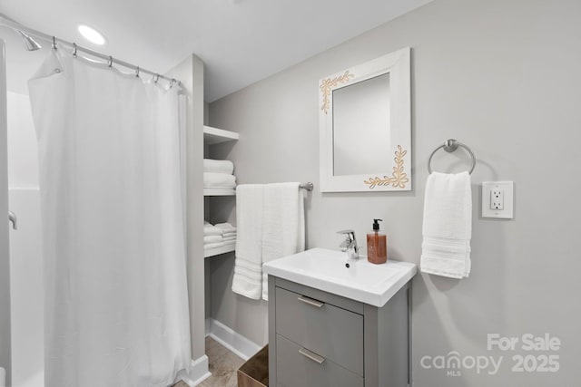 full bathroom with vanity, a shower with curtain, and baseboards