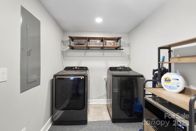 washroom with electric panel, washing machine and dryer, tile patterned flooring, baseboards, and laundry area