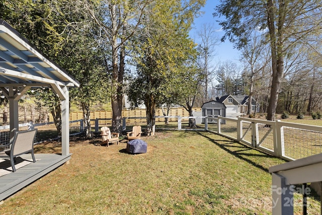 view of yard featuring a storage unit, an outbuilding, and a fenced backyard