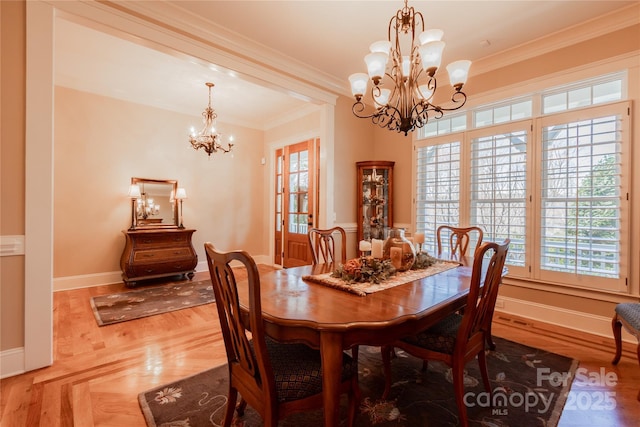 dining room with crown molding, baseboards, and an inviting chandelier