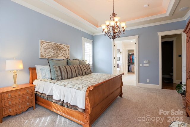 carpeted bedroom with a notable chandelier, baseboards, a tray ceiling, and crown molding