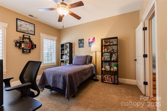 carpeted bedroom with baseboards, visible vents, and ceiling fan