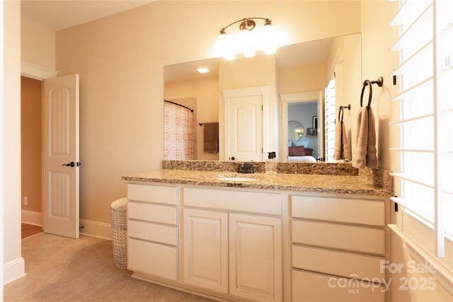 ensuite bathroom featuring vanity, baseboards, and ensuite bathroom