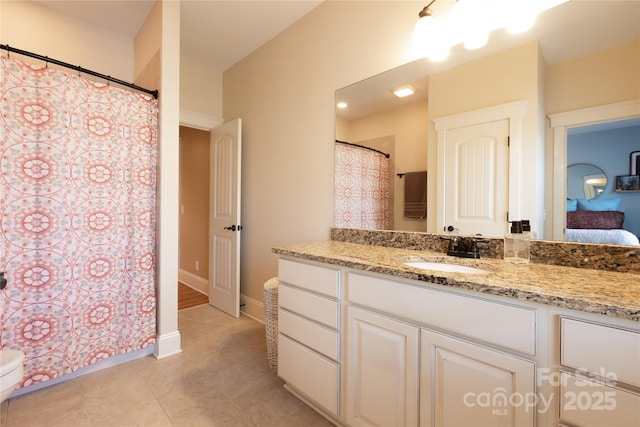 full bath with tile patterned flooring, vanity, baseboards, and ensuite bathroom