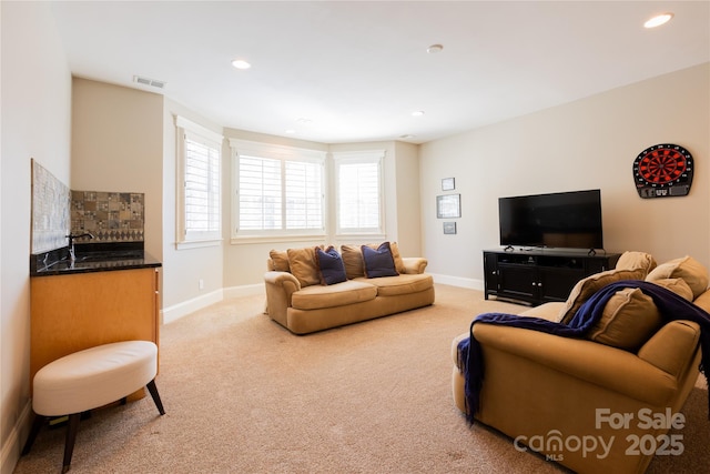 living area featuring recessed lighting, light carpet, visible vents, and baseboards