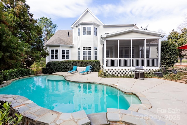 pool with a sunroom, a patio, and fence