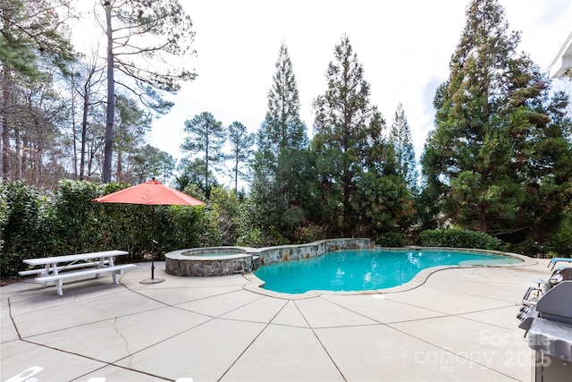 view of swimming pool featuring a patio area and a pool with connected hot tub