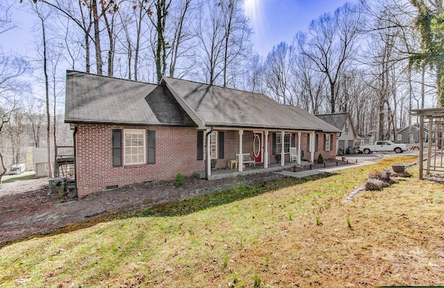 view of front facade with a front yard, crawl space, and brick siding