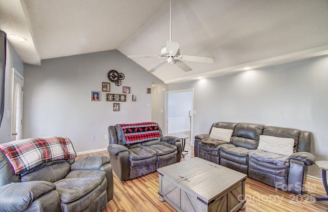 living room with vaulted ceiling, ceiling fan, light wood-type flooring, and baseboards