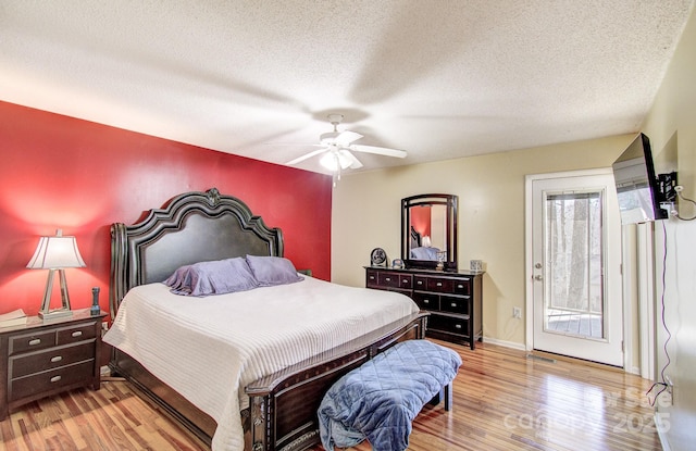 bedroom with light wood finished floors, access to outside, baseboards, and a textured ceiling