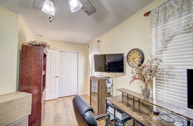 home office featuring ceiling fan, a textured ceiling, and light wood finished floors