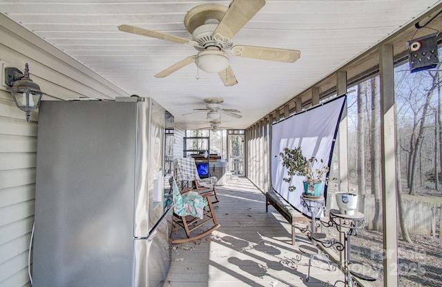 unfurnished sunroom featuring ceiling fan