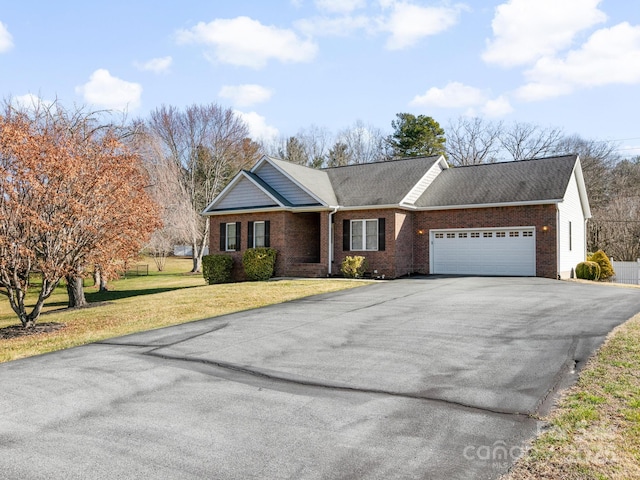 ranch-style home with an attached garage, brick siding, aphalt driveway, and a front yard