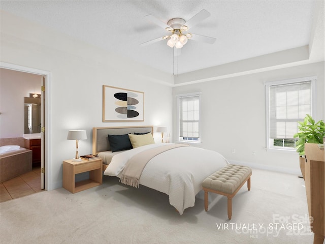 carpeted bedroom featuring ceiling fan, a textured ceiling, and ensuite bath