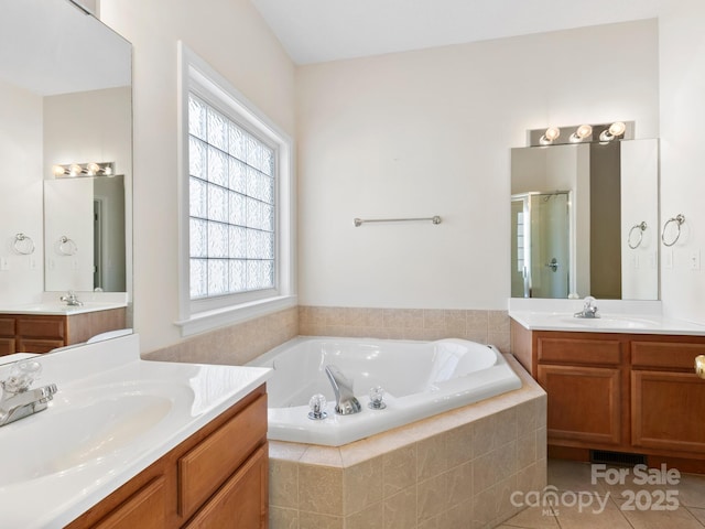 full bath with a stall shower, tile patterned flooring, a garden tub, and a sink