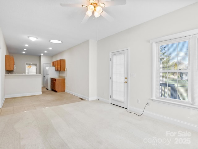 unfurnished living room featuring light carpet, recessed lighting, baseboards, a ceiling fan, and light tile patterned flooring