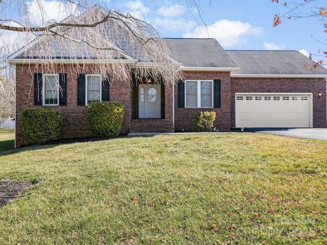 view of front of home featuring a garage, a front lawn, and brick siding