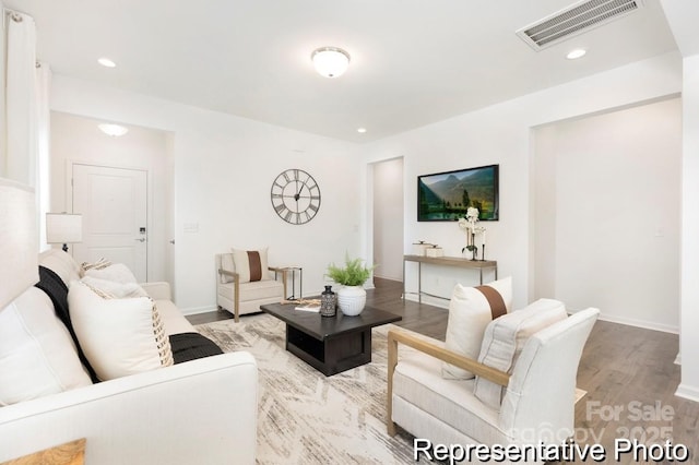 living area with light wood-style flooring, visible vents, baseboards, and recessed lighting