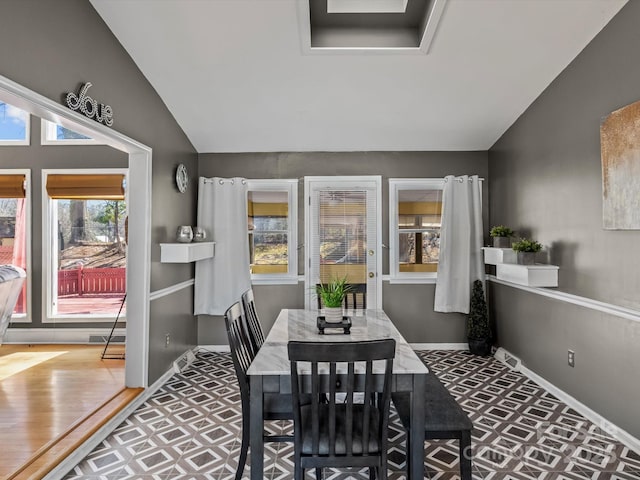 dining space with visible vents, vaulted ceiling, baseboards, and wood finished floors