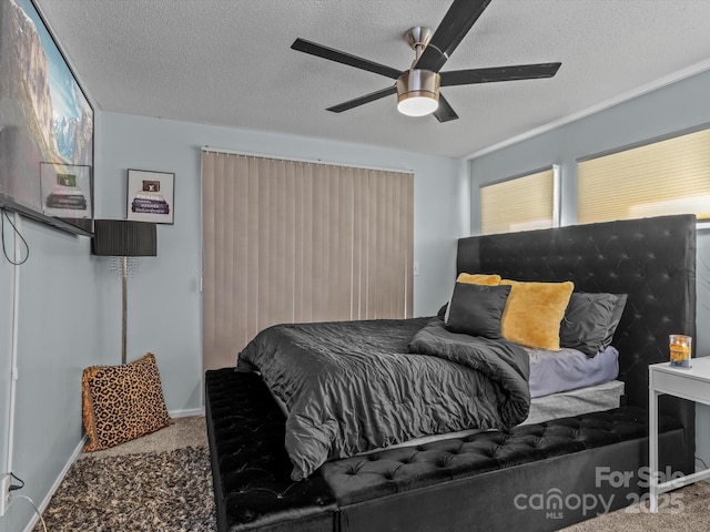 bedroom featuring baseboards, a textured ceiling, a ceiling fan, and carpet flooring