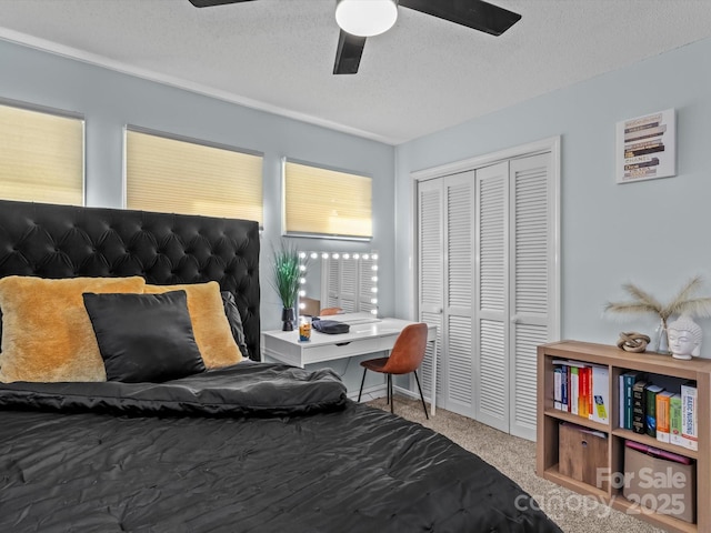 carpeted bedroom with a closet, ceiling fan, and a textured ceiling