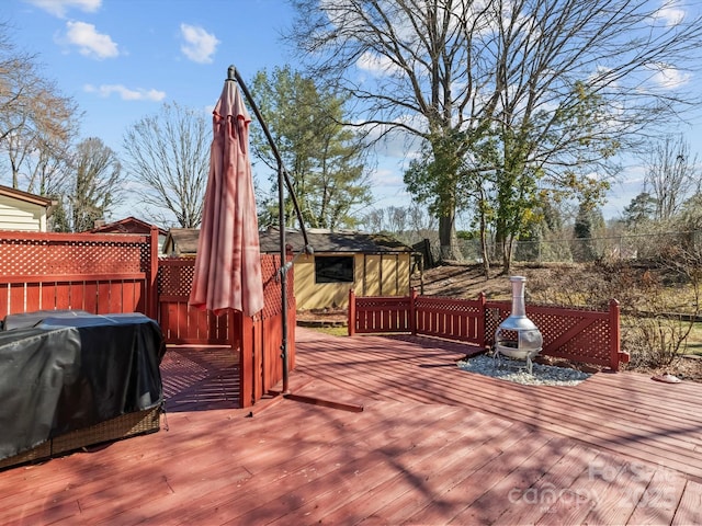 wooden terrace with an outbuilding and fence