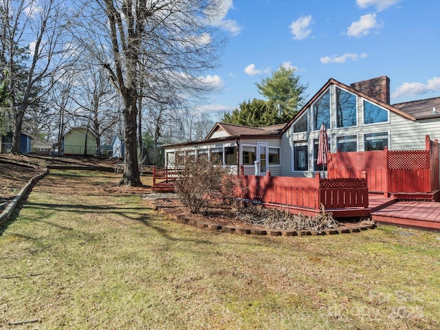 rear view of property with a yard and a wooden deck