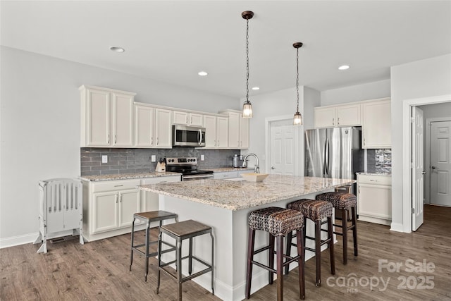 kitchen with white cabinetry, stainless steel appliances, and a kitchen breakfast bar