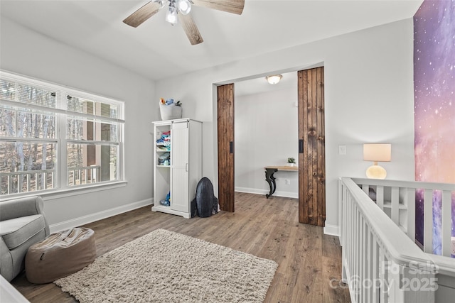 bedroom featuring wood finished floors, a ceiling fan, and baseboards