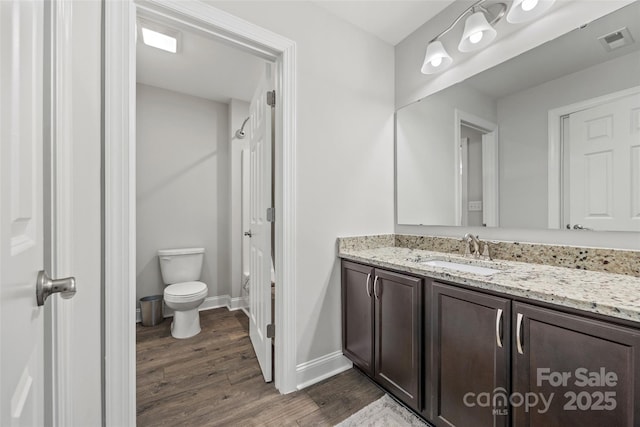 full bathroom featuring toilet, wood finished floors, vanity, visible vents, and baseboards