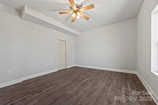 spare room featuring a ceiling fan, dark wood-style flooring, and baseboards