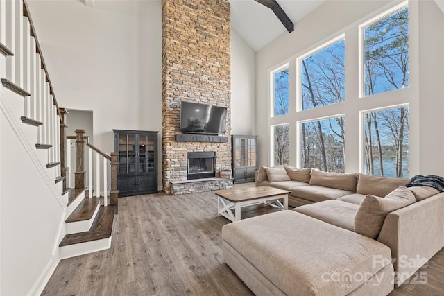 13701 Petworth Ct, Charlotte, NC 28278 - living room featuring high vaulted ceiling, a fireplace, stairway, wood finished floors, and baseboards