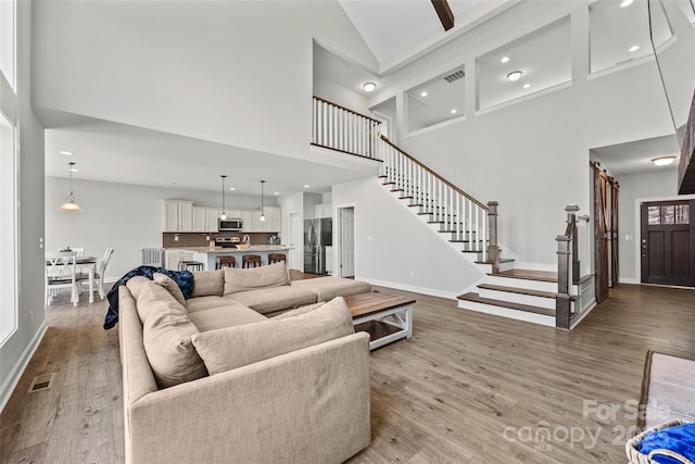 13701 Petworth Ct, Charlotte, NC 28278 - living area featuring high vaulted ceiling, stairs, baseboards, light wood finished floors, and recessed lighting