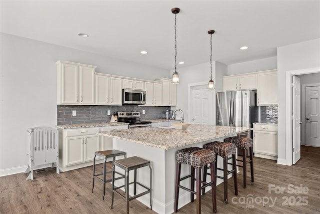 13701 Petworth Ct, Charlotte, NC 28278 - kitchen with appliances with stainless steel finishes, a kitchen bar, tasteful backsplash, white cabinetry, and recessed lighting