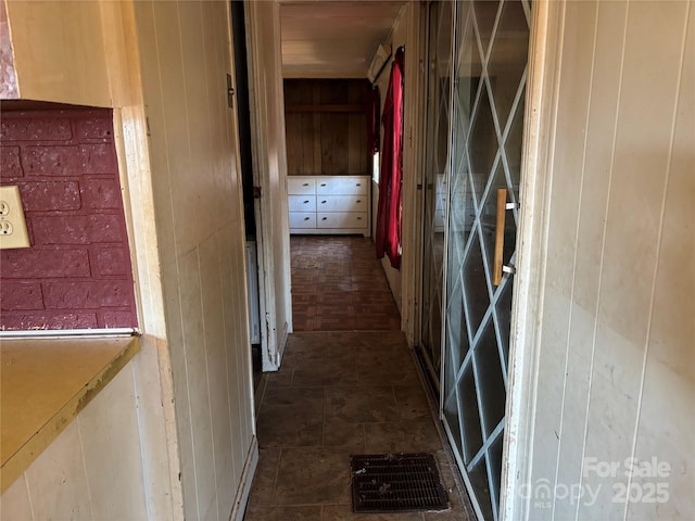 hallway featuring wood walls