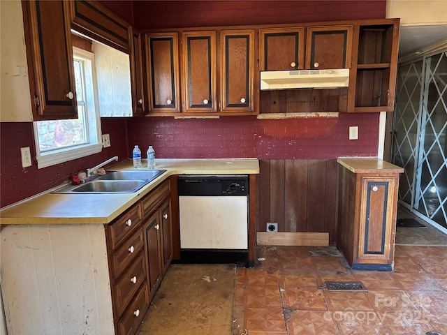 kitchen featuring dishwasher, light countertops, a sink, and under cabinet range hood