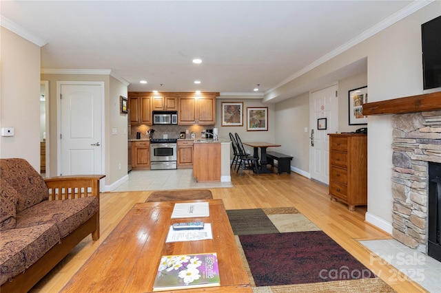 living area featuring recessed lighting, a fireplace, baseboards, light wood-style floors, and ornamental molding