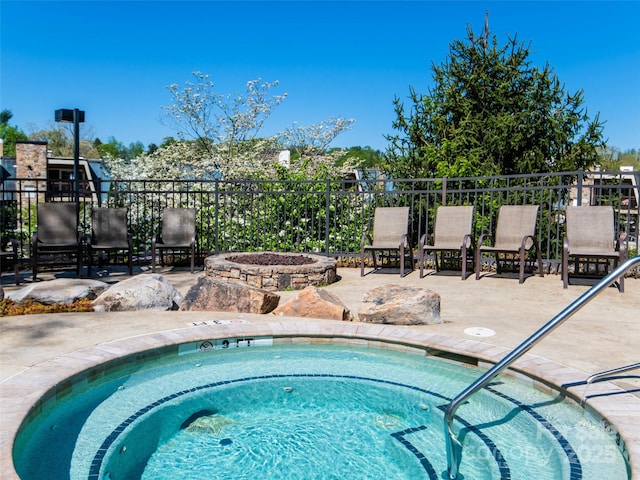 view of pool with a patio area, fence, and a community hot tub