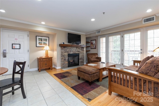 living room with plenty of natural light, visible vents, and crown molding