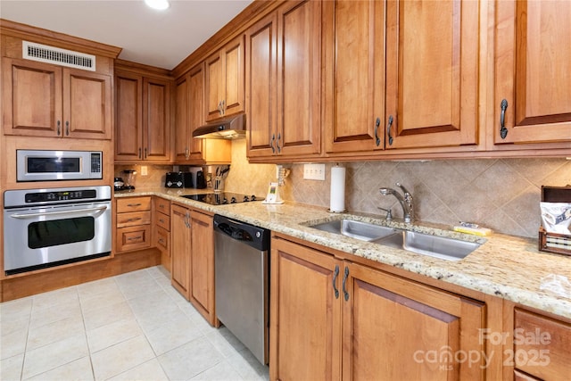 kitchen with under cabinet range hood, a sink, visible vents, appliances with stainless steel finishes, and decorative backsplash